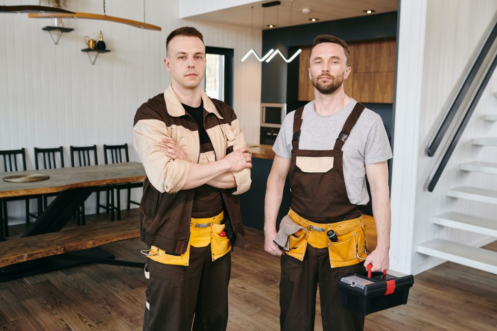 Two plumbers or repairmen in workwear